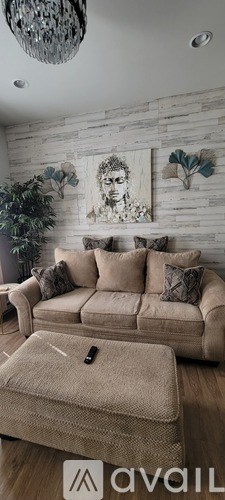 A living room with a beige sofa and a chandelier.
