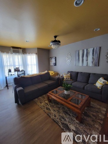 A living room with a grey couch and a wooden coffee table.
