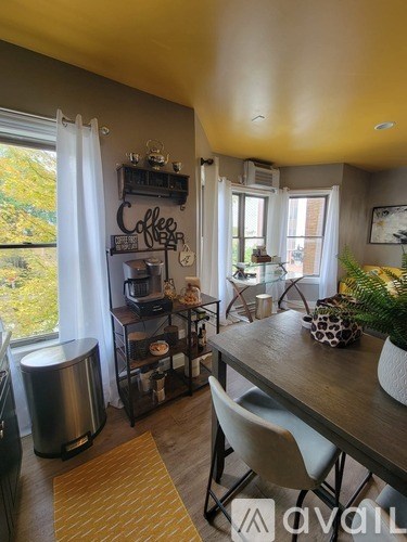 A kitchen with a wooden table and white chairs.