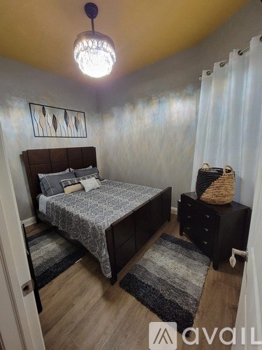 A bedroom with a bed, nightstand, and a rug.