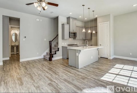 A spacious kitchen with a staircase leading to the upper floor.