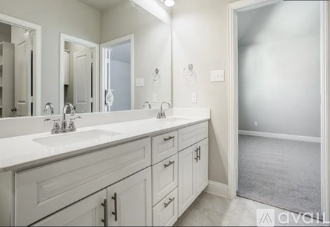 A bathroom with two sinks and a large mirror.