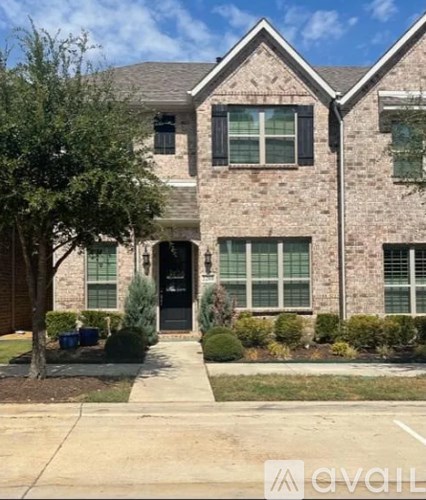 A brick house with a black front door and windows.