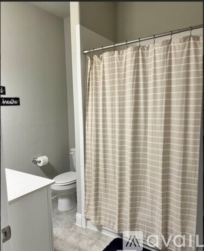 A beige checkered shower curtain in a bathroom.