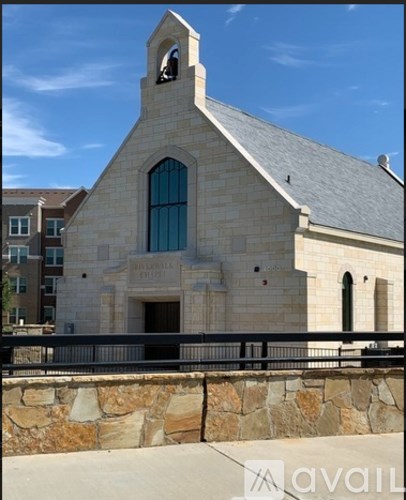 A stone building with a large arched window and a bell tower.