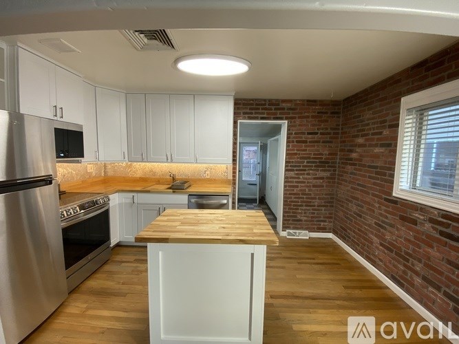 A kitchen with wooden floors and white cabinets.