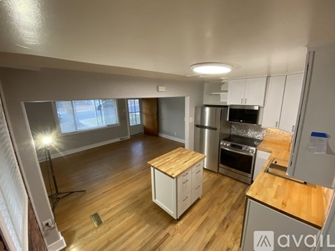 A kitchen with wooden floors and white cabinets is available for rent.