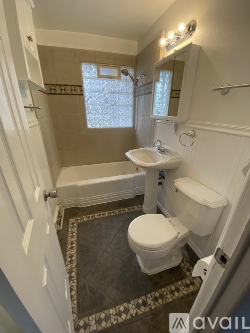 A bathroom with a toilet, sink, and bathtub.