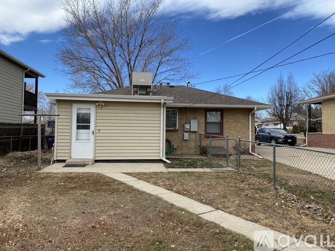 A small house with a white door and a brown roof.