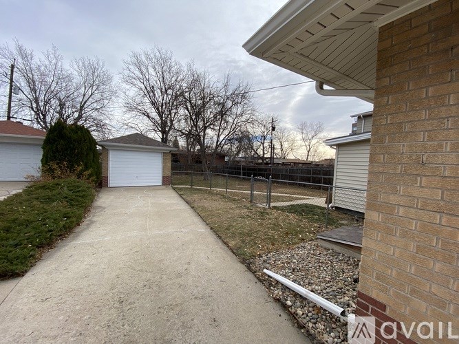A backyard with a concrete pathway leading to a garage.