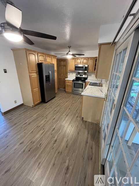 A kitchen with wooden cabinets and a black refrigerator.