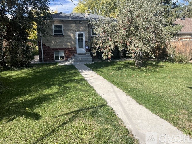 A house with a white door and a tree in front of it.