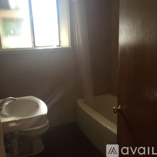 A bathroom with a toilet, sink, and bathtub.