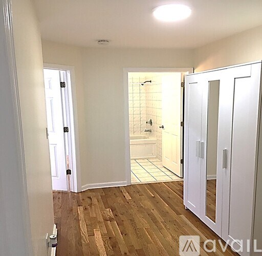 A bathroom with a walk-in shower and wooden flooring.