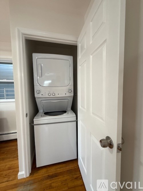 A white washing machine is built into a wall in a room.