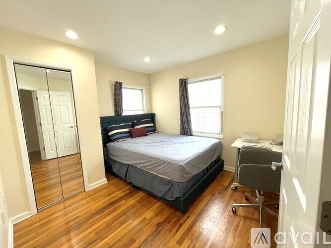 A bedroom with a bed, desk, and chair.