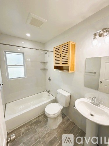A bathroom with a toilet, sink, and bathtub.