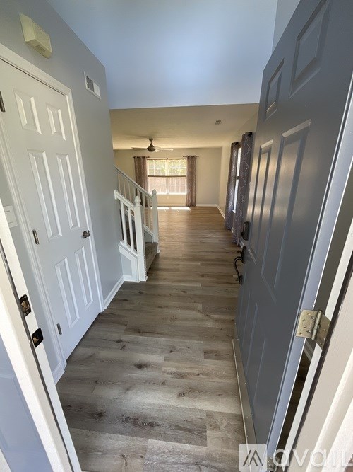 A hallway with white doors and wooden floors.