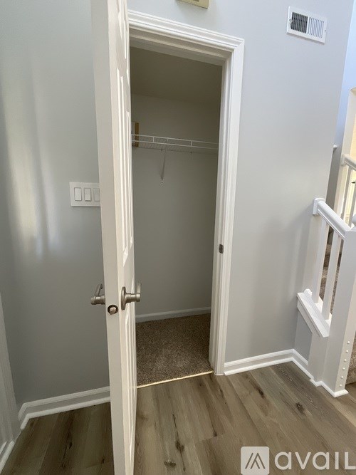 A white door is open to a small closet.