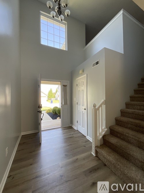 A hallway with a staircase leading to the second floor.