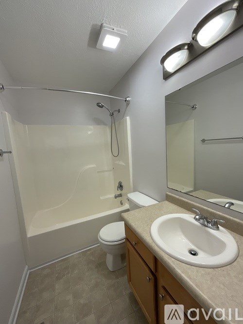 A bathroom with a toilet, sink, and shower.