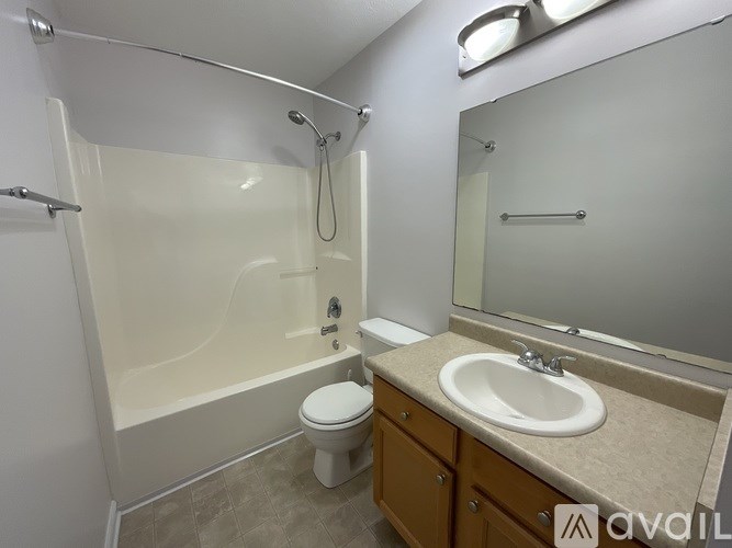 A bathroom with a white toilet, sink, and bathtub.