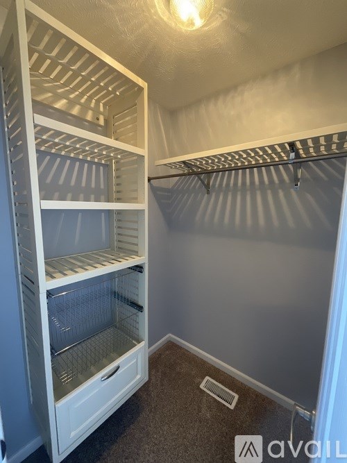 A white refrigerator with a drawer and a shelf is in a room.