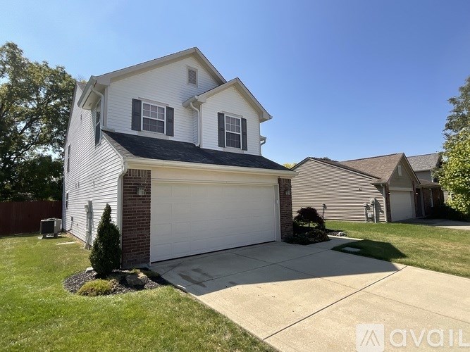 A two-story house with a garage is for sale.