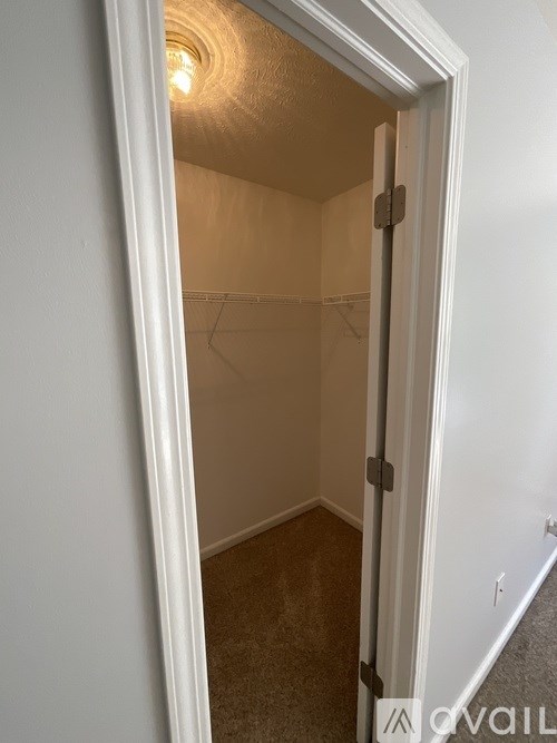 A white door is open to a small, empty room.