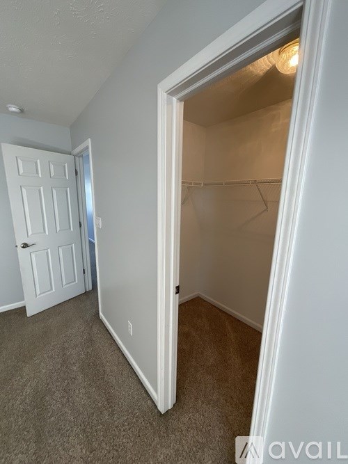 A room with a white door and a white wall with a small window.