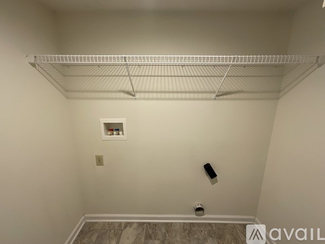 Empty white closet with a shelf and a light switch.