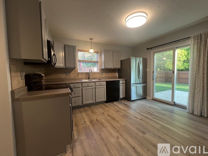 A kitchen with wooden floors and a large window.