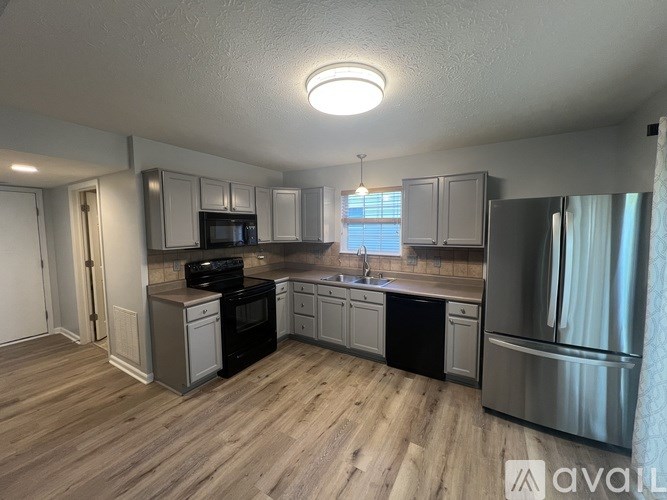 A kitchen with wooden floors and stainless steel appliances is available for rent.