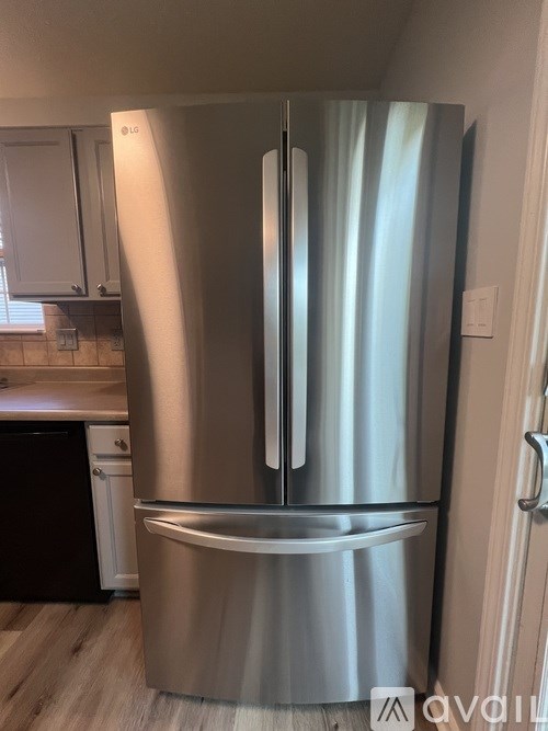 A stainless steel refrigerator in a kitchen.