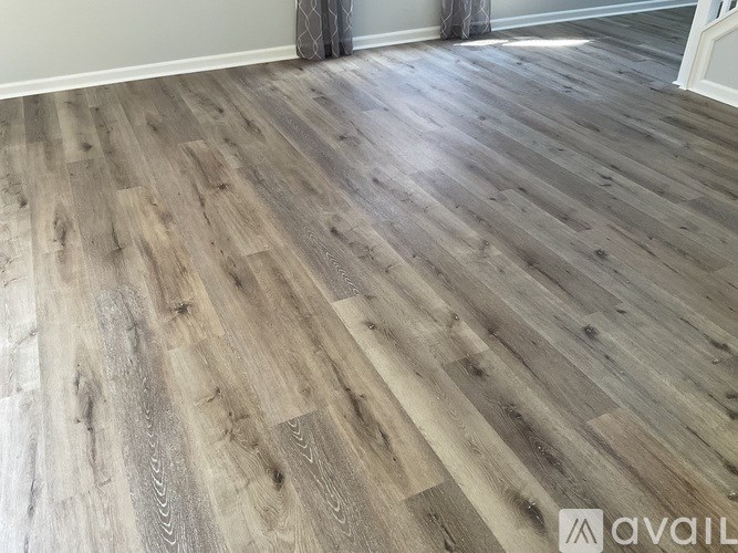 A room with a wooden floor and a white wall.