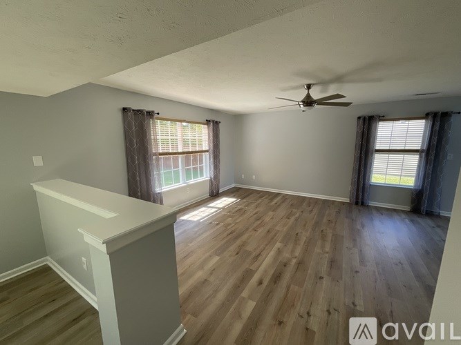 A room with wooden floors and a ceiling fan.