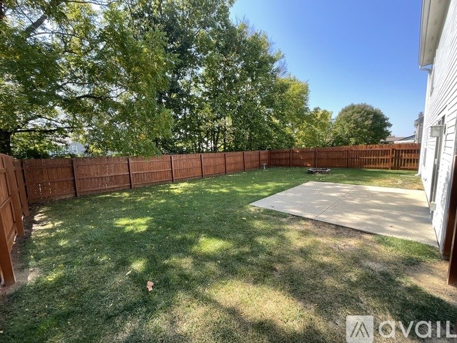 A backyard with a wooden fence and a green lawn.