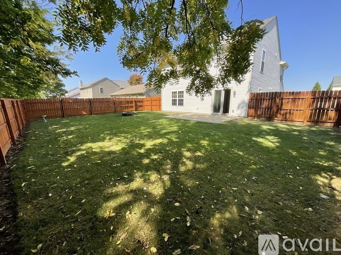 A backyard with a fence and a house in the background.