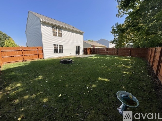 A white house with a fence and a green lawn.