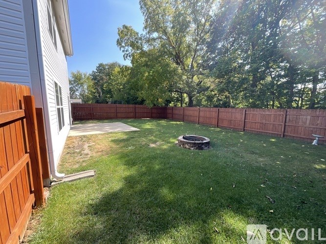A backyard with a wooden fence and a fire pit.