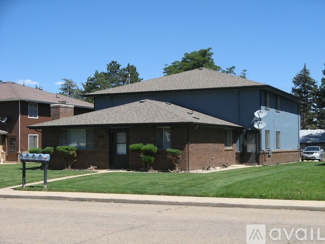 A house with a grey roof and a mailbox in front.