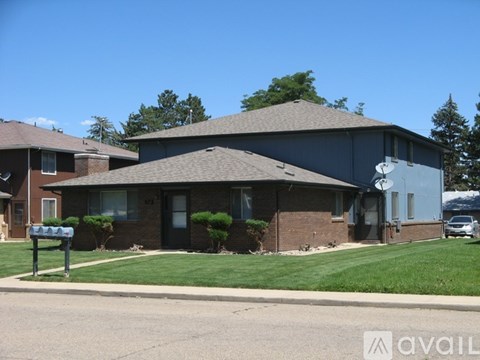 A house with a grey roof and a mailbox in front.