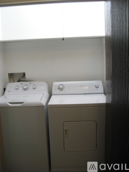 Two washing machines in a small laundry room.