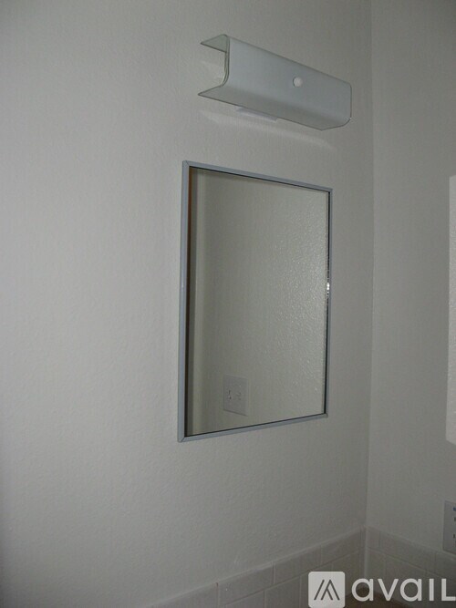 A mirror is hanging on a wall above a light switch.