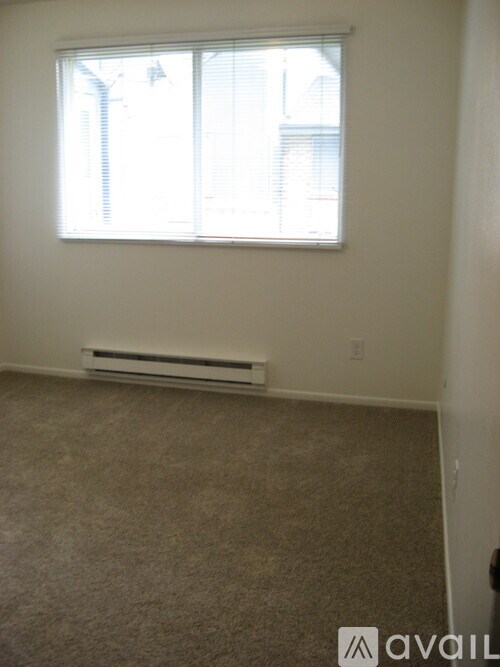 A room with a window and a wall-mounted air conditioner.