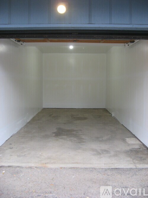 A large empty room with a concrete floor and white walls.
