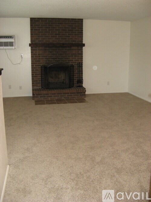 A room with a fireplace and carpeted floor.