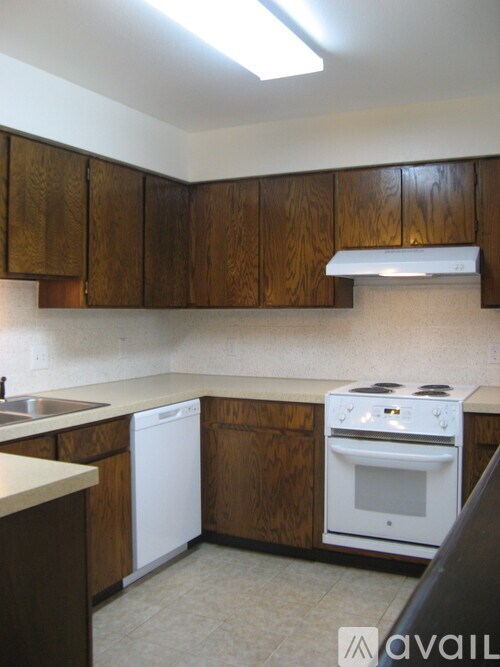 A kitchen with wooden cabinets and a white dishwasher.