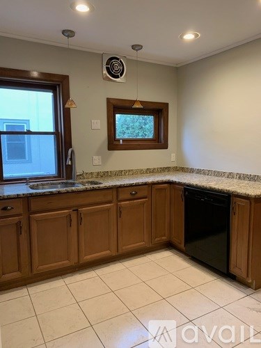 A kitchen with wooden cabinets and a granite countertop.
