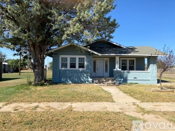 A blue house with a tree in front of it.